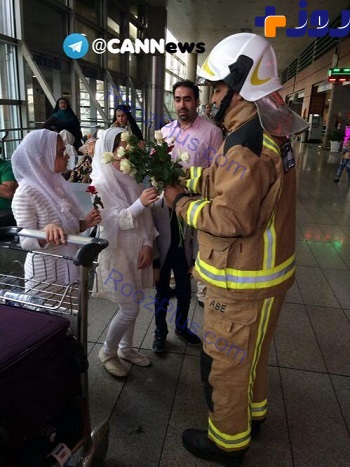 پخش گل با لباس آتش نشان، به مسافران در فرودگاه امام خمينى