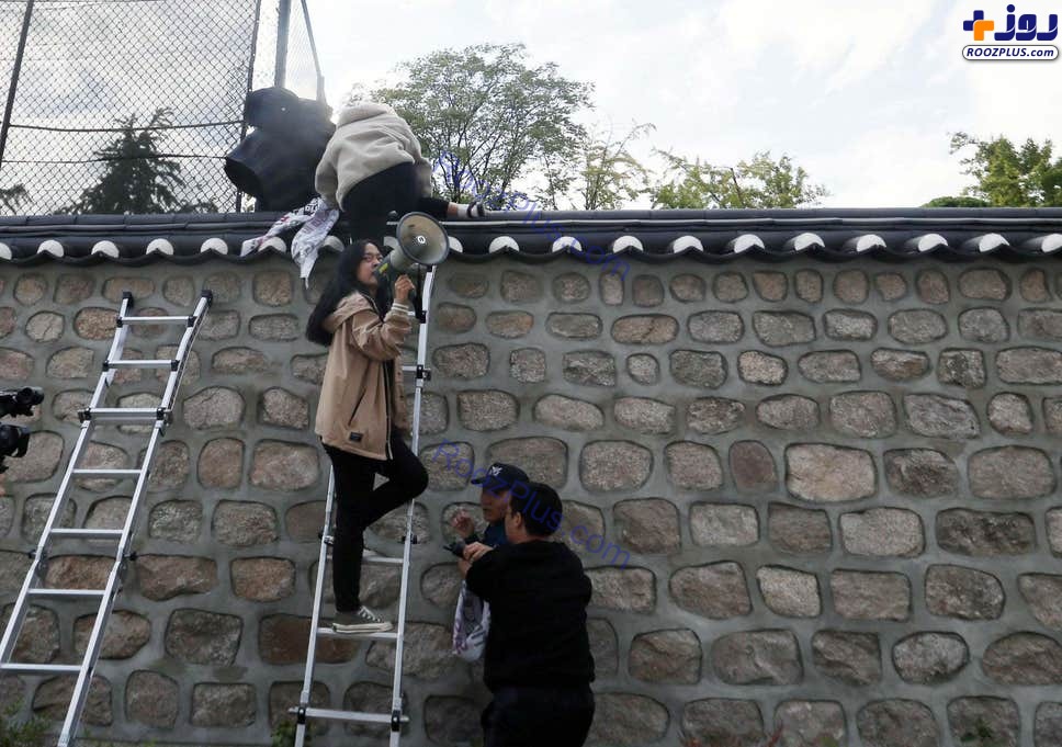 عکس/ بالا رفتن دانشجویان معترض کره‌ جنوبی از دیوار اقامتگاه سفیر آمریکا