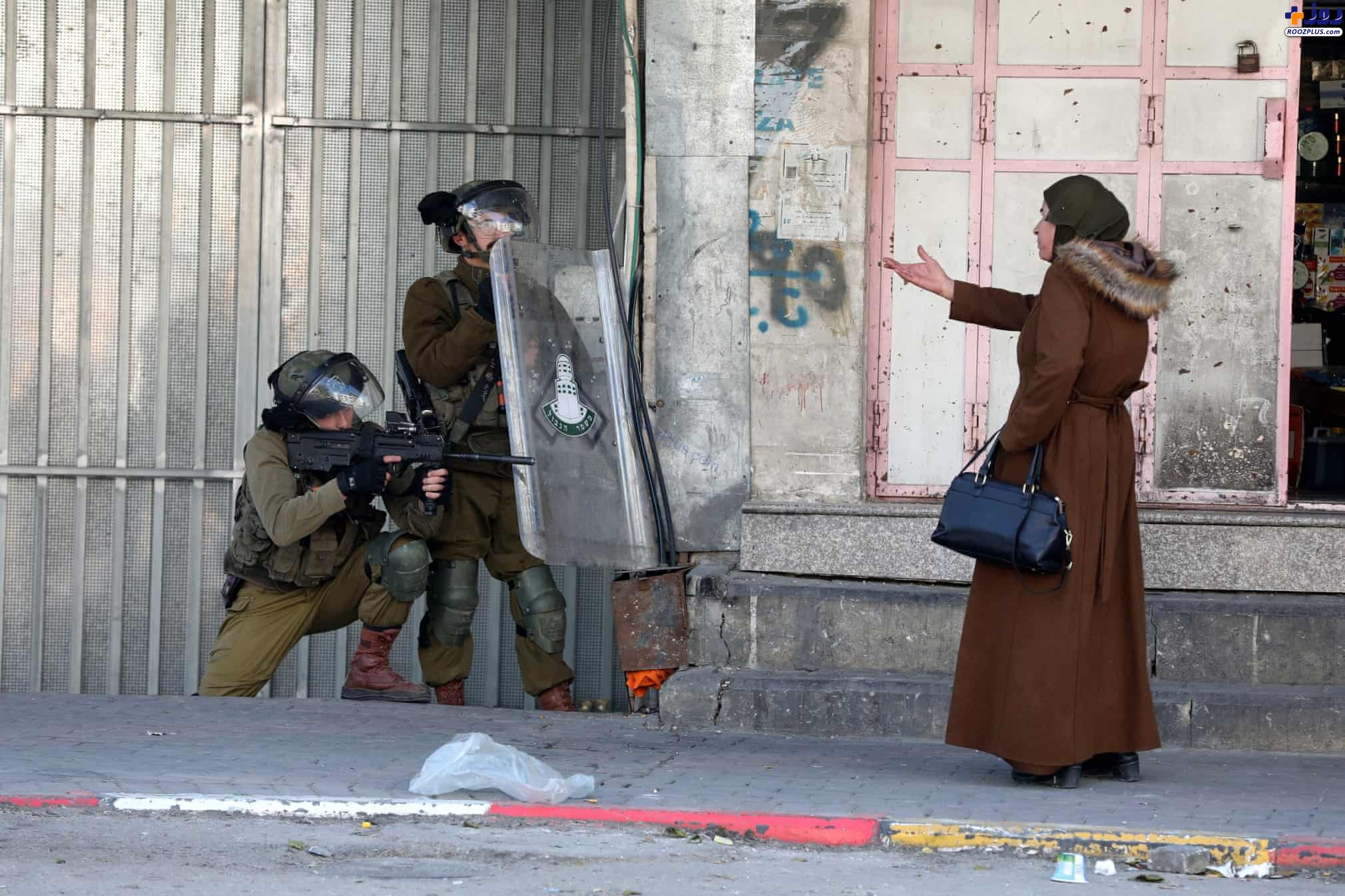 عکس/ اعتراض یک زن فلسطینی به سربازان اسرائیلیِ تا دندان مسلح!