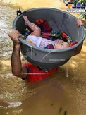 حمل جالب و عجیب یک کودک در میان سیلاب+عکس