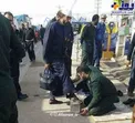 تصويري از خدمت بي ريا يك پاسدار در حال تميز كردن كفش زائرين اربعین