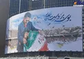 عکس/ بوسه امیر عابدزاده به دستان پدر، روی دیوارنگاره میدان ولیعصر